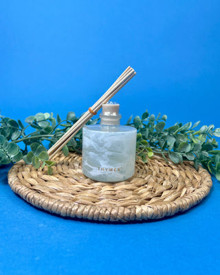 Shop the Thymes Frasier Fir Tidings Petite Reed Diffuser with marbled glass vessel and iconic evergreen fragrance for flameless holiday scent.