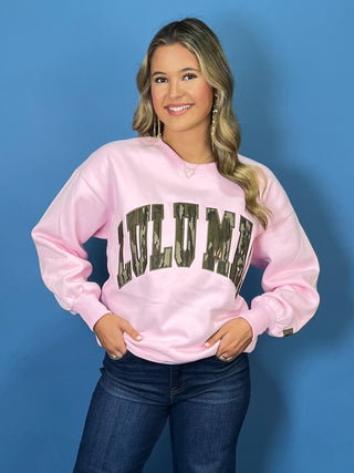 Pink long sleeve crewneck sweatshirt featuring oversized “LULU MAC” lettering with a camouflage print