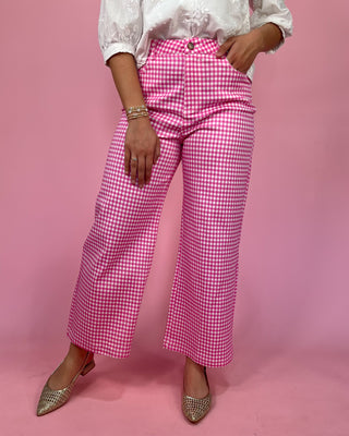 Person wearing pink checkered pants on a pink background