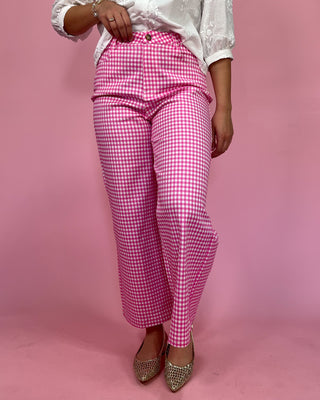 Person wearing pink checkered pants on a pink background