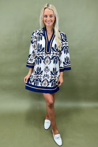 Woman wearing a blue and white patterned dress on a green background