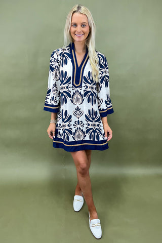 Woman wearing a patterned dress with a plain background