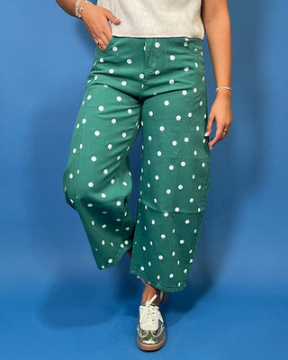 Green high-rise wide leg cropped jeans with an allover white polka dot print, front pockets, and seam detailing.