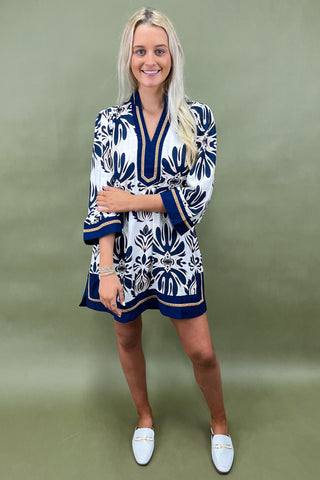 Woman wearing a patterned dress with a green background