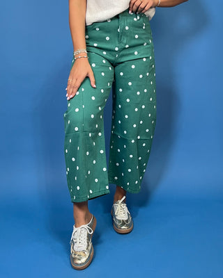 Green high-rise wide leg cropped jeans with an allover white polka dot print, front pockets, and seam detailing.