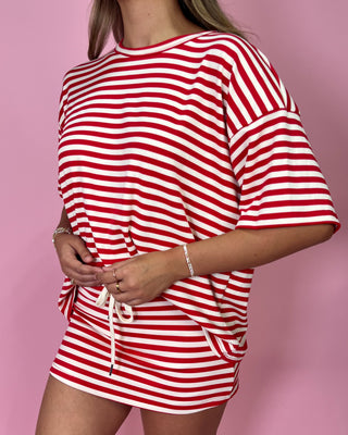Red and white striped outfit on a pink background