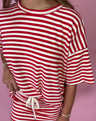 Red and white striped outfit on a pink background