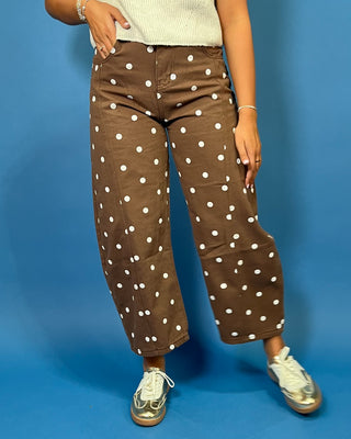 Chocolate brown high-rise cropped wide leg jeans with an allover ivory polka dot print, front pockets, and seam detailing.