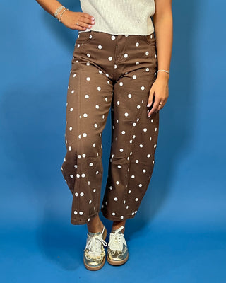 Chocolate brown high-rise cropped wide leg jeans with an allover ivory polka dot print, front pockets, and seam detailing.