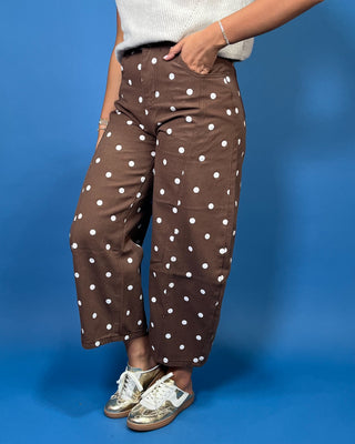 Chocolate brown high-rise cropped wide leg jeans with an allover ivory polka dot print, front pockets, and seam detailing.