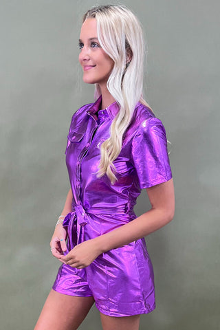 Woman wearing a shiny purple outfit against a gray background