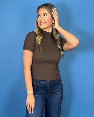 Chocolate brown ribbed mock neck top with short sleeves, a fitted silhouette, and delicate scalloped trim.