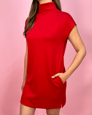 Red sleeveless dress worn by a person on a pink background