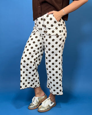 Ivory wide leg pants with brown polka dots, scalloped trim, front pockets, and a cropped fit.