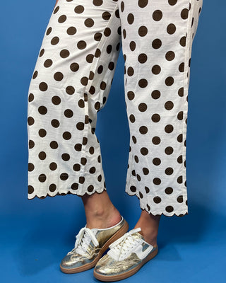 Ivory wide leg pants with brown polka dots, scalloped trim, front pockets, and a cropped fit.