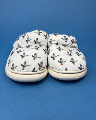 Cozy white duck slippers with cushioned interior displayed against a solid blue background. 