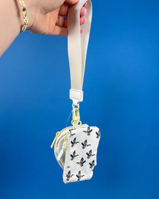 White duck print dual pouch wristlet with detachable strap, two zippered compartments, and gold-tone hardware.