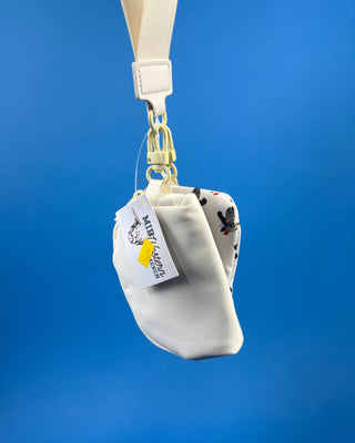 White duck print dual pouch wristlet with detachable strap, two zippered compartments, and gold-tone hardware.