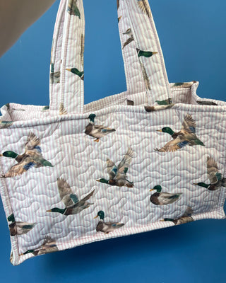 Quilted Ida Mae Home tote bag with watercolor mallard duck print, striped fabric, spacious interior, and padded shoulder straps.