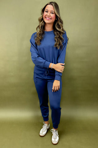 Woman wearing a blue outfit against a green background