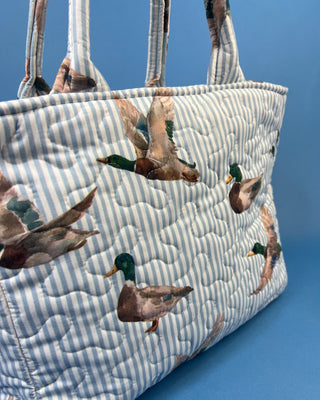 Ida Mae Home quilted handbag with pink and blue striped fabric, mallard duck print, padded shoulder straps, and spacious open interior.