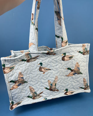 Quilted Ida Mae Home tote bag with watercolor mallard duck print, striped fabric, spacious interior, and padded shoulder straps.