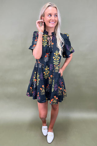 Woman wearing a floral dress on a plain background