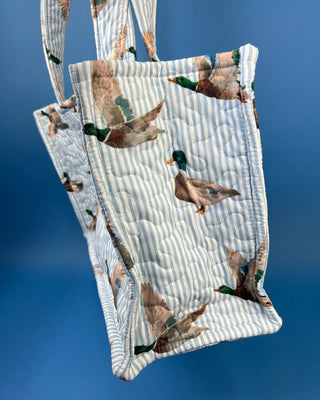 Quilted Ida Mae Home tote bag with watercolor mallard duck print, striped fabric, spacious interior, and padded shoulder straps.