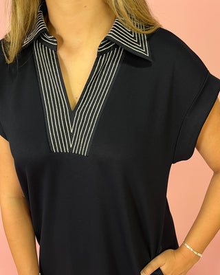 Black blouse with white striped collar on a pink background