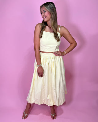 Woman wearing a white dress against a pink background
