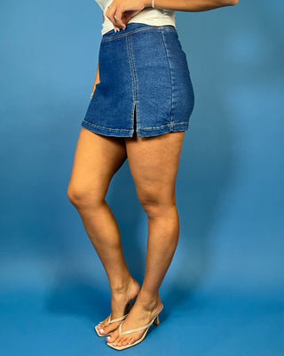 Dark wash denim skort with a flattering fitted silhouette, contrast stitching, and a chic front slit detail.