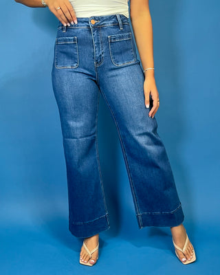 Medium wash high-rise wide leg jeans with front patch pockets, subtle fading, and statement cuffed hems.