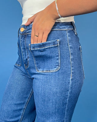 Medium wash high-rise wide leg jeans with front patch pockets, subtle fading, and statement cuffed hems.
