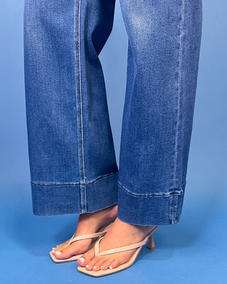 Medium wash high-rise wide leg jeans with front patch pockets, subtle fading, and statement cuffed hems.