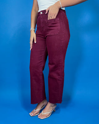 Burgundy high-rise cropped straight leg jeans with front patch pockets and a trendy raw hem.