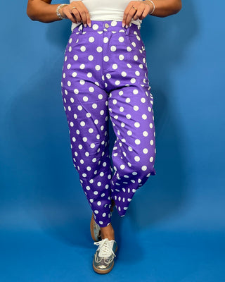 Purple high-rise polka dot pants with bold white dots, a flattering straight-leg silhouette, and cropped ankle length.
