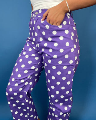 Purple high-rise polka dot pants with bold white dots, a flattering straight-leg silhouette, and cropped ankle length.