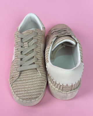 Beige woven sneaker with white sole against a pink background