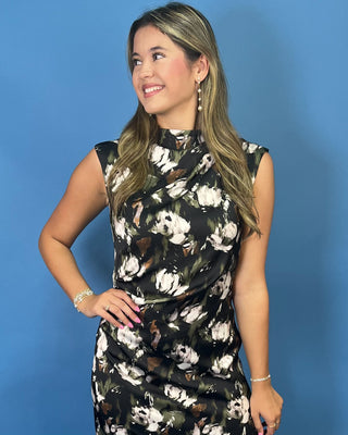 A woman modeling a sleeveless high-neck dress with a black base and a white floral pattern