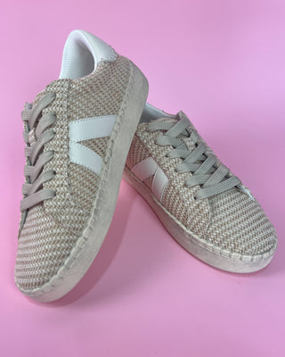 Beige woven sneaker with white sole against a pink background