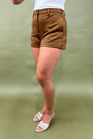 Brown shorts worn by a person on a green background