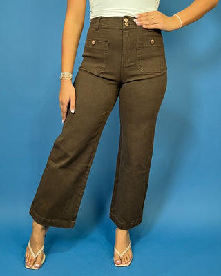 Chocolate brown high-rise wide leg pants with gold button details, front patch pockets, and a flattering cropped silhouette.