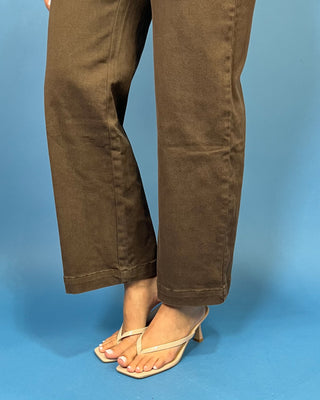 Chocolate brown high-rise wide leg pants with gold button details, front patch pockets, and a flattering cropped silhouette.