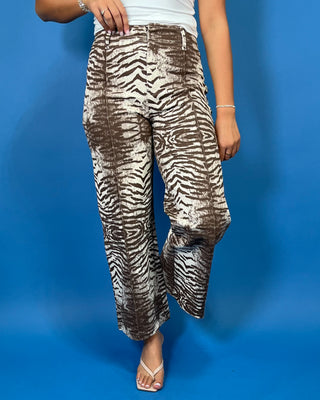 Brown and cream zebra print high-rise pants with a wide-leg silhouette, cropped length, and bold allover animal print.