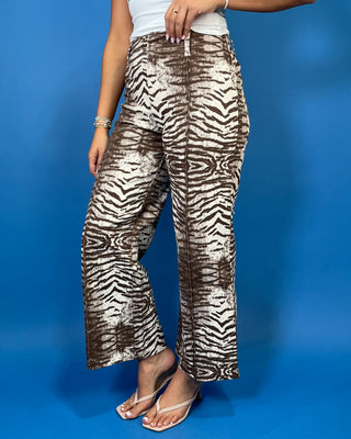 Brown and cream zebra print high-rise pants with a wide-leg silhouette, cropped length, and bold allover animal print.