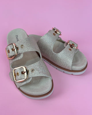 Gold glitter double-buckle slide sandal with cushioned footbed on pink background