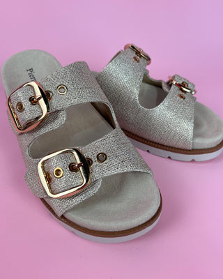 Gold glitter double-buckle slide sandal with cushioned footbed on pink background