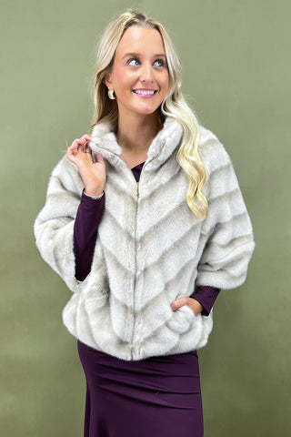 Woman wearing a fur coat against a green background