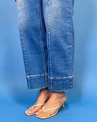 Medium wash high-rise cropped wide leg jeans with front seam detailing, subtle fading, a wide cuffed hem, and small front hem slits.