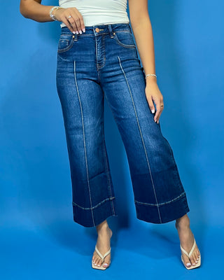 Dark wash high-rise cropped wide leg jeans with statement front seam detailing, subtle fading, and a wide cuffed hem.